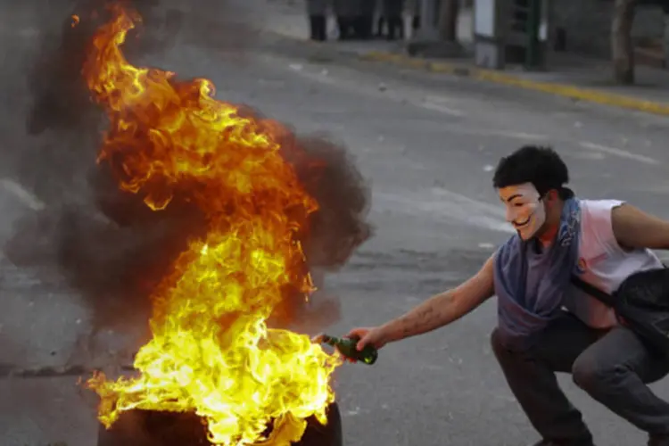 Manifestante anti-governo acende um coquetel molotov durante confrontos na praça Altamira, em Caracas, na Venezuela  (Marco Bello/Reuters)