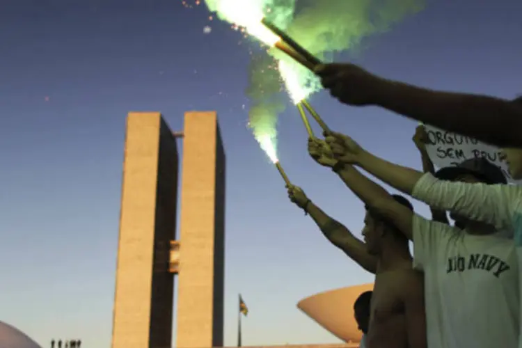 Manifestantes acendem sinalizadores em protesto em frente ao Congresso Nacional, em Brasília (REUTERS)