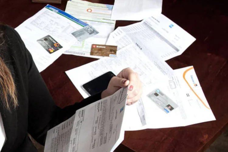 
	Mulher olha documentos e contas: declara&ccedil;&atilde;o completa de IR &eacute; exigida para que a imobili&aacute;ria verifique toda a situa&ccedil;&atilde;o patrimonial do futuro inquilino
 (Paulo Pampolin)
