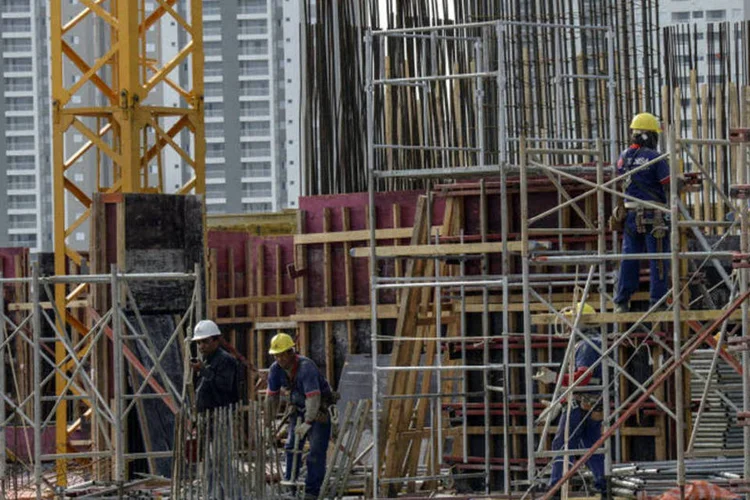
	Oper&aacute;rios trabalhando na constru&ccedil;&atilde;o de um pr&eacute;dio da Tecnisa
 (Paulo Fridman/Bloomberg)