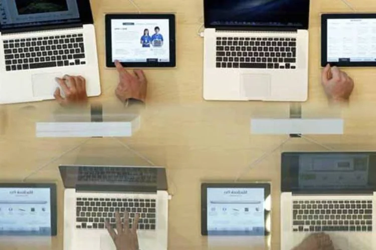 
	Consumidores olham modelos do MacBook Pro durante a abertura de uma loja da Apple na Espanha: 4,1 milh&otilde;es de Macs foram vendidos pela empresa no trimestre encerrado em dezembro
 (REUTERS/Albert Gea/Arquivo)