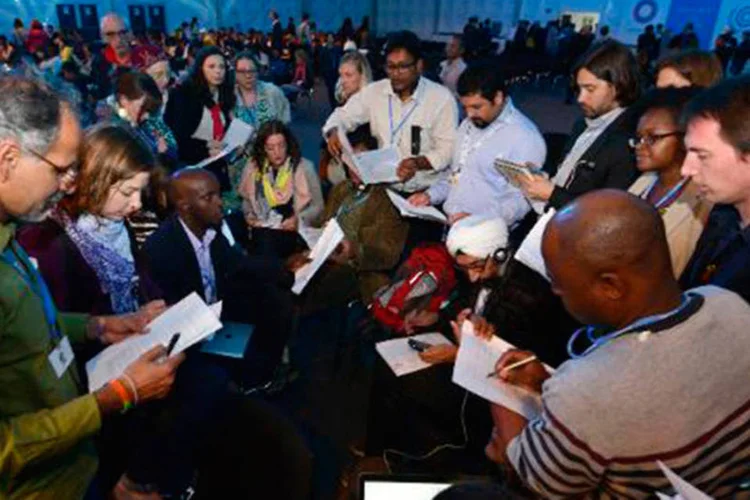 Representantes de ONGs na COP20 discutem o documento de compromisso proposto pelo Presidente e ministro do Meio Ambiente peruano Manuel Pulgar, pouco antes da meia-noite do dia 14 de dezembro de 2014
 (CRIS BOURONCLE/AFP)