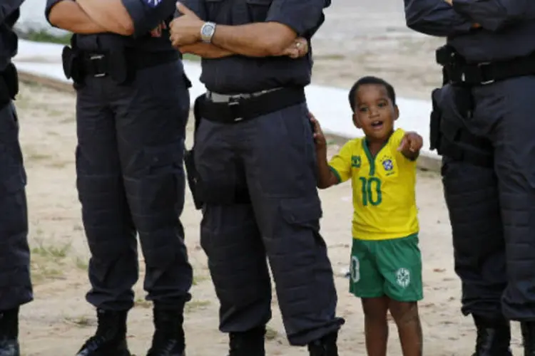
	Um menino fica no meio de policiais durante evento da Copa do Mundo
 (REUTERS/Toru Hanai)