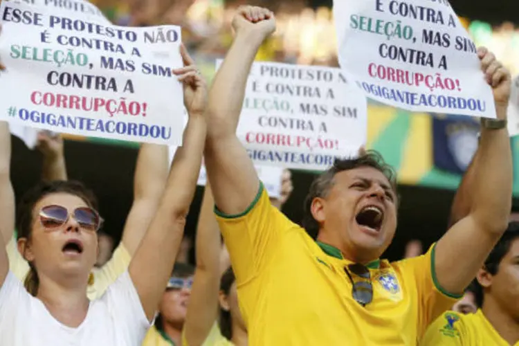 
	Torcedores carregam cartazes de protestos durante jogo do Brasil contra o M&eacute;xico: as manifesta&ccedil;&otilde;es deste s&aacute;bado n&atilde;o foram organizadas por uma institui&ccedil;&atilde;o social espec&iacute;fica
 (REUTERS/Jorge Silva)