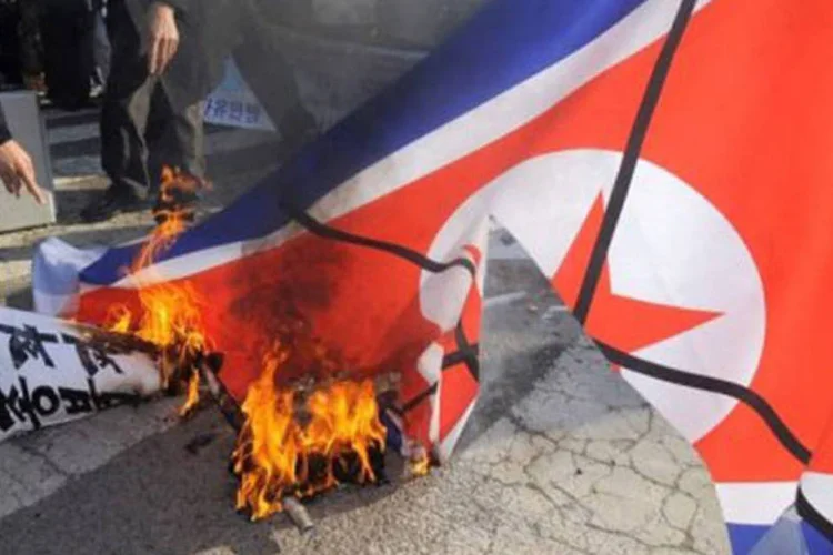 Sul coreanos queimam a bandeira da Coreia do Norte em protesto aos bombardeios feitos pelo país à ilha de Yeonpyeong (Park Ji-Hwan/AFP)