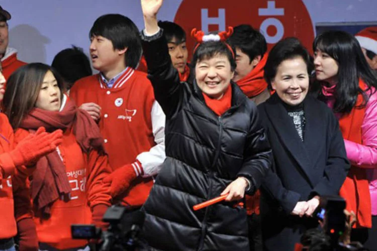 
	A candidata do partido conservador, Park Geun-Hye, acena para eleitores em Seul: 40% dos votos foram apurados
 (Jung Yeon-Je/AFP)