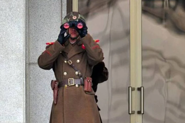 Soldado norte-coreano observa o lado sul-coreano da fronteira na localidade de Panmunjom, na zona desmilitarizada que divide os dois países, em 12 de março
 (Jung Yeon-Je/AFP)
