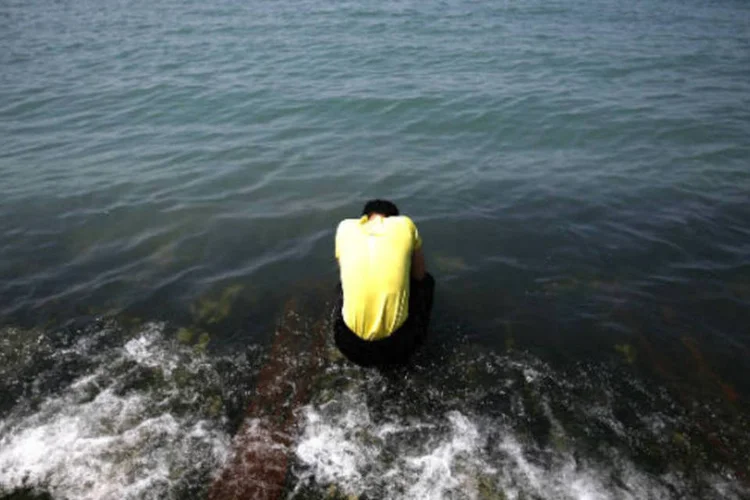 
	Um familiar de uma v&iacute;tima do naufr&aacute;gio do Sewol reza diante do mar: sexta-feira outro parente foi achado em casa com sintomas de overdose de rem&eacute;dios e foi levado a um hospital
 (REUTERS/Kim Kyung-Hoon)