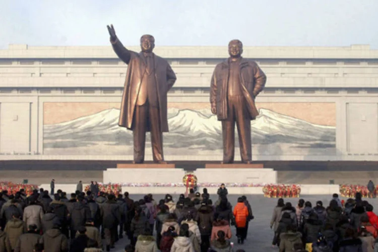 
	Norte-coreanos em frente &agrave; est&aacute;tuas de Kim Il Sung e Kim Jong Il: Imprensa era obrigada a ocultar informa&ccedil;&otilde;es sobre o progresso de outros pa&iacute;ses, segundo jornalista
 (Divulgação/KCNA)