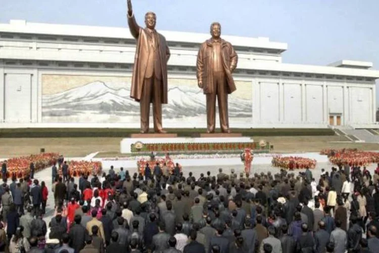 Soldados da Coreia do Norte, trabalhadores e estudantes colocam flores nas estátuas do fundador do país, Kim II-sung e seu filho, Kim Jong-Il (Reuters/KCNA)