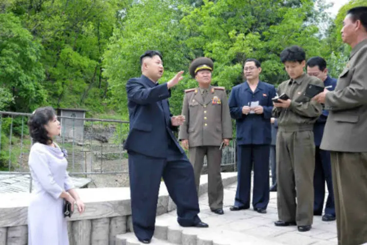 
	L&iacute;der norte-coreano Kim Jong-un e sua esposa Ri Sol-ju conversam com militares
 (REUTERS / KCNA)