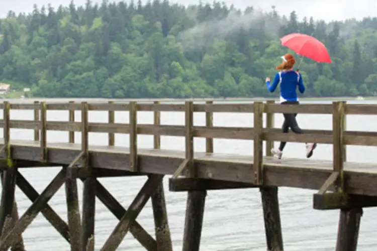 Mulher correndo na chuva: uma grande tempestade ou um calor fora de época também pode sabotar seus planos para o dia D (Getty Images)