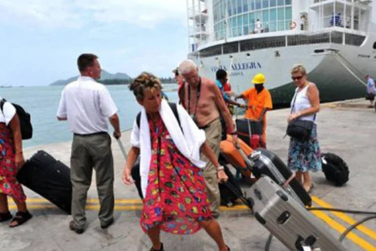 Os turistas, desorientados, fatigados, mas com um sorriso de alívio, procuravam por sua bagagem, colocadas no cais
 (Alberto Pizzoli/AFP)