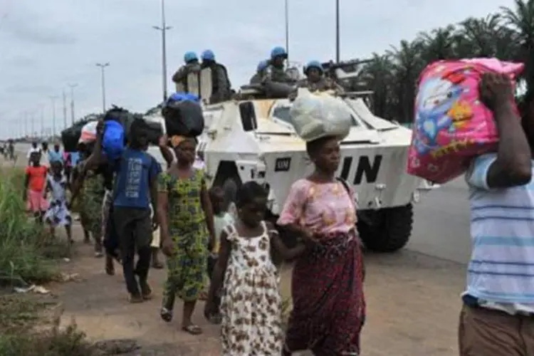 Civis deixam Adibjan, na Costa do Marfim: batalha na cidade iniciada em 31 de março (Issouf Sanogo/AFP)