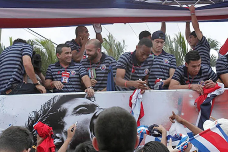 Jogadores da Costa Rica distribuem autógrafos aos torcedores na volta à San Jose (REUTERS/Juan Carlos Ulate)