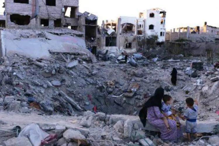 
	Mulher observa a cratera no local onde ficava a sua casa, em Jabalia, Faixa de Gaza
 (Roberto Schmidt/AFP)