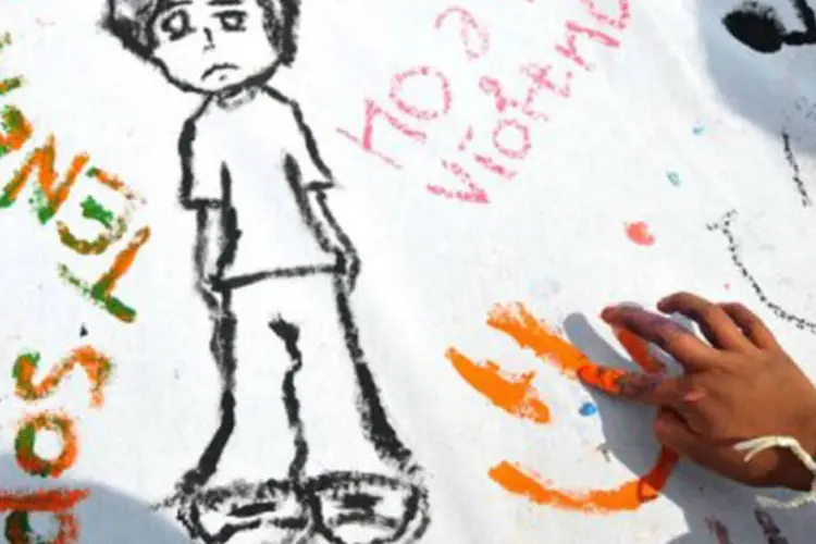 Criança faz desenhos em homenagem ao "Dia contra a Violência contra a Criança e o Adolescente": taxa de mortes violentas entre jovens subiu 375,9% em 30 anos (Johan Ordonez/AFP)