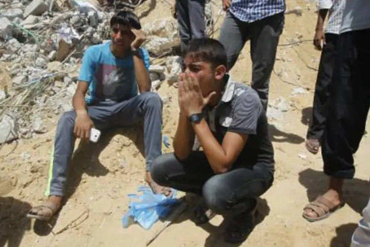 
	Palestinos choram ao verem o resgate do corpo de uma crian&ccedil;a de escombros ap&oacute;s um ataque no sul da Faixa de Gaza
 (Said Jatib/AFP)