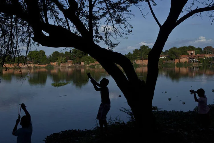 Crianças brincam com estilingues em lago nos subúrbios de Teresina, no Piauí (Dado Galdieri/Bloomberg)