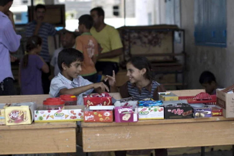 Crianças palestinas em banca de doces em escola de Gaza (AFP/Getty Images)