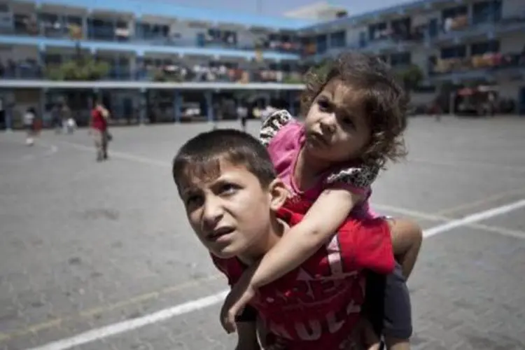 
	Crian&ccedil;as palestinas em quadra de escola da ONU: tr&eacute;gua deve durar 72 horas
 (Mahmud Hams/AFP)