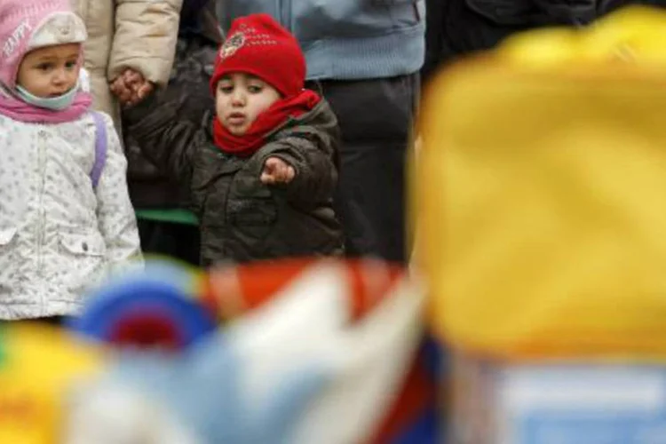 
	Crian&ccedil;as olham para brinquedos que estavam sendo doados: ladr&otilde;es devolveram 50 presentes
 (Cesar Manso/AFP)