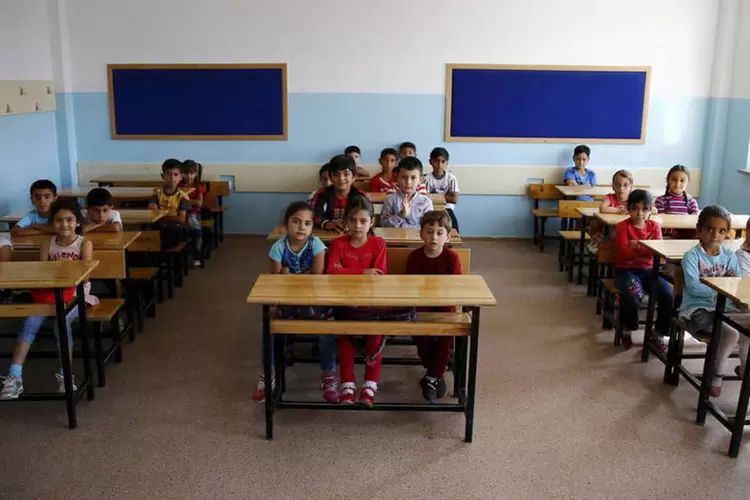 
	Crian&ccedil;as refugiadas s&iacute;rias na sala de aula: ao mesmo tempo, o pedagogo manifestou-se contra o estabelecimento de turmas integralmente composta por refugiados no ensino regular
 (Reuters / Umit Bektas)