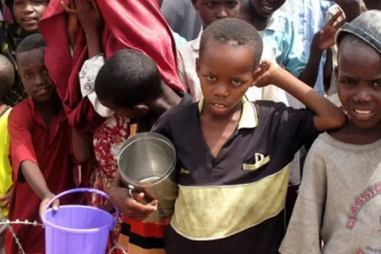 Crianças esperam com baldes e panelas nas mãos a distribuição de comida em um campo para refugiados em: segundo a ONU, se trata da "pior crise alimentar" (Ali Musa/AFP)