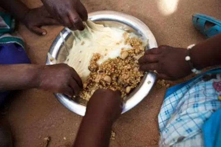Crianças se alimentam em um centro de distribuição de alimentos no Sudão (Albert Gonzalez Farran/AFP)