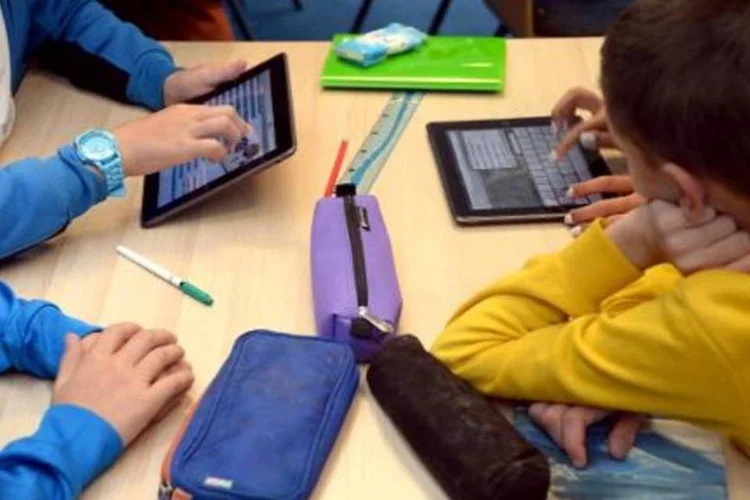 Crianças utilizam tablets em escola: a Eutelsat, no entanto, não informa o montante da operação (Damien Meyer/AFP)