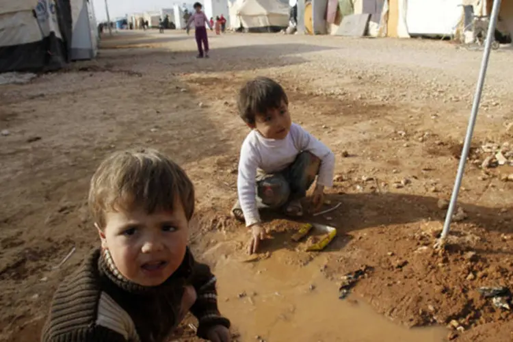 Crianças refugiadas sírias brincam do lado de fora da tenda de seus pais no campo de Al Zaatri, na cidade de Mafraq, Jordânia (Ali Jarekji/Reuters)