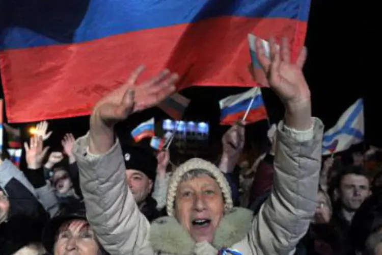 
	Habitantes da Crimeia comemoram vit&oacute;ria em referendo: &quot;os cidad&atilde;os de fala russa n&atilde;o foram v&iacute;timas de amea&ccedil;a na Crimeia&quot;, afirmou um relat&oacute;rio da ONU
 (Viktor Drachev/AFP)