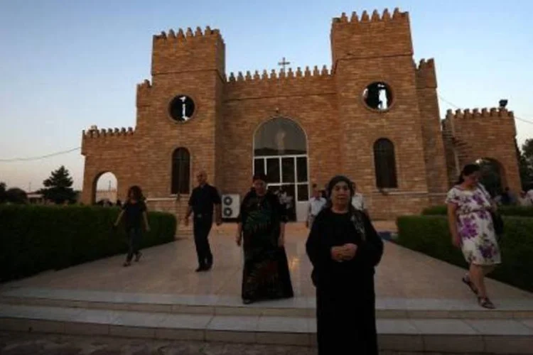 Cristãos iraquianos deixam uma igreja de Erbil, capital da região autônoma do Curdistão (Safin Hamed/AFP)