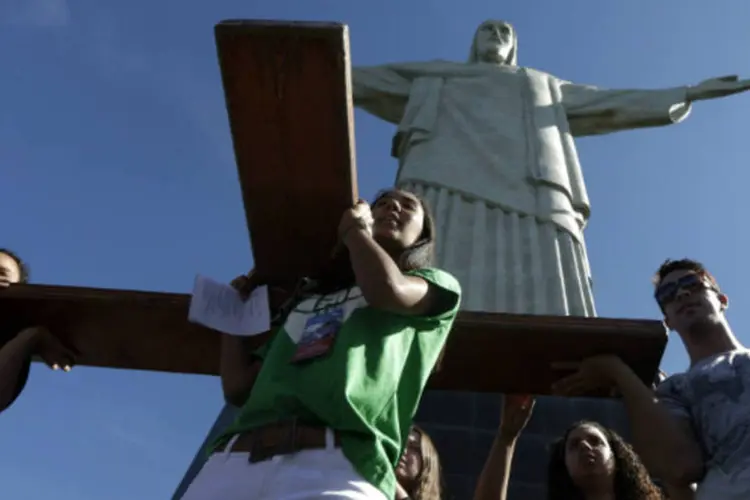 Jovens carregam a cruz da Jornada Mundial da Juventude durante visita a estátua do Cristo Redentor no Rio de Janeiro (Ricardo Moraes/Reuters)