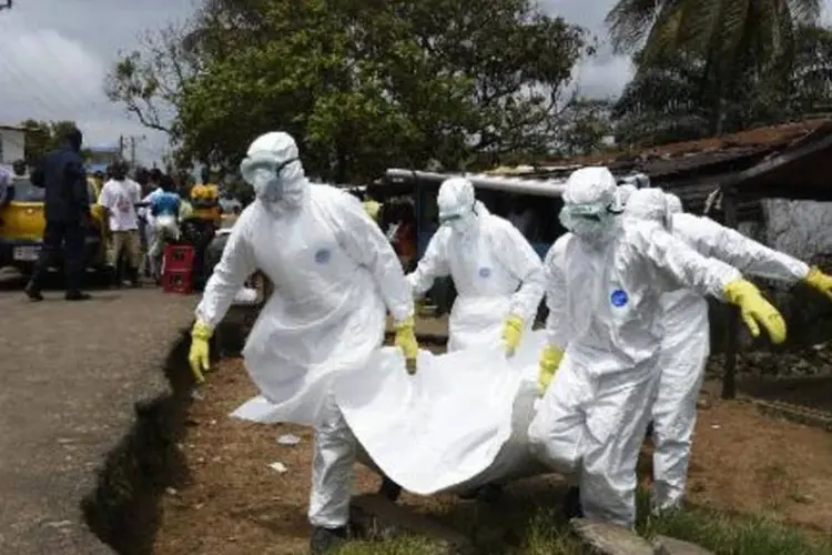 
	Membros da Cruz Vermelha transportam o corpo de uma v&iacute;tima do ebola, na Lib&eacute;ria
 (Pascal Guyot/AFP)
