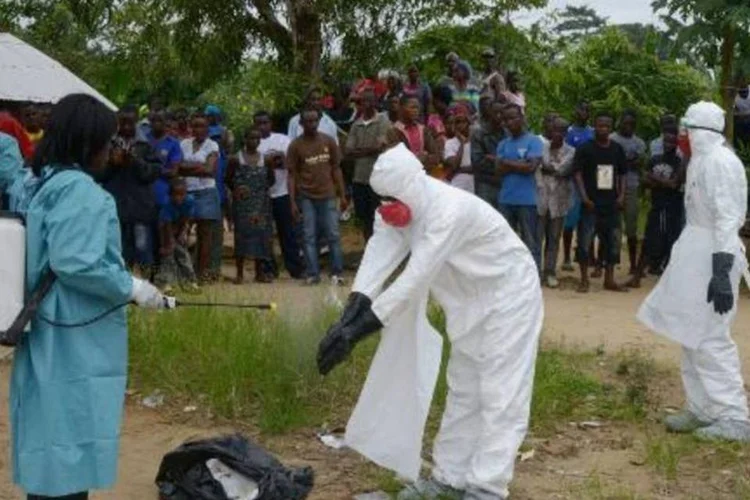 Membros da Cruz Vermelha desinfectando roupas para evitar infecção do ebola (Dominique Faget/AFP)