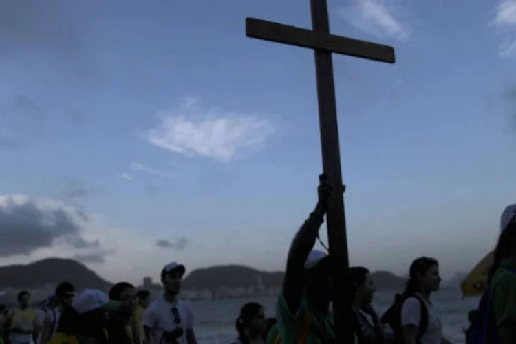
	Fi&eacute;is carregam cruz na praia de Copacabana, no Rio de Janeiro, durante a chegada para a Jornada Mundial da Juventude, que contar&aacute; com a presen&ccedil;a do papa Francisco
 (REUTERS/Ueslei Marcelino)