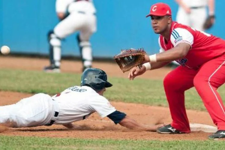 O jogador cubano José Dariel Abreu (d) participa de jogo de beisebol em Havana (AFP)
