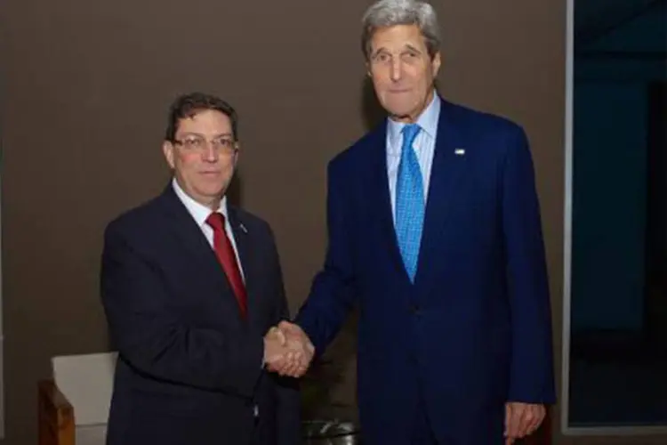 O secretário de Estado americano, John Kerry (D), aperta a mão do chanceler cubano, Bruno Rodríguez, no Panamá na véspera da Cúpula das Américas
 (AFP)
