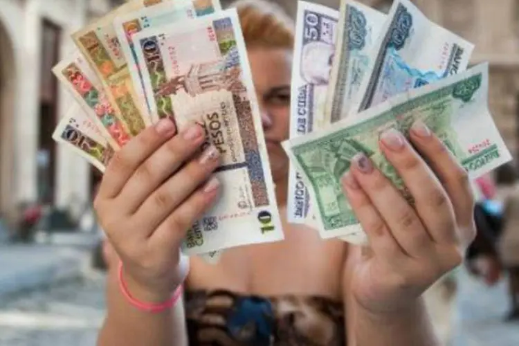 Cubana segura pesos cubanos e pesos conversíveis: há vinte anos, duas moedas circulam na ilha (AFP)