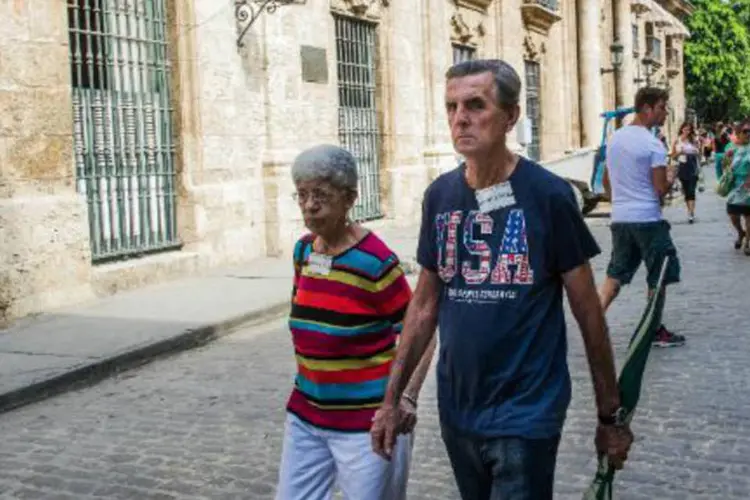 Cubano usando camiseta com bandeira dos Estados Unidos caminha por rua de Havana (Yamil Lage/AFP)