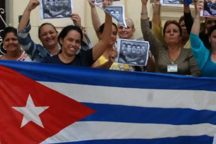 
	Cubanos comemoram not&iacute;cia sobre a reaproxima&ccedil;&atilde;o entre Cuba e EUA: n&atilde;o ficou imediatamente claro como as viagens dos imigrantes ser&atilde;o custeadas
 (Roberto Morejon/AFP)