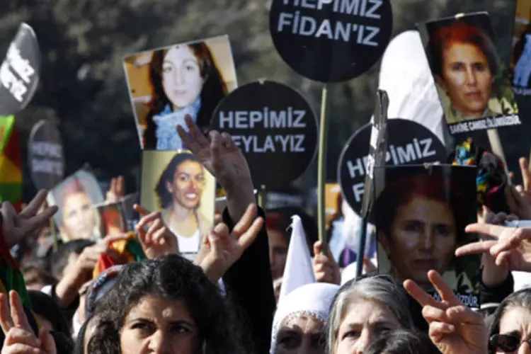 Pessoas seguram cartazes em funeral das três ativistas curdas mortas em Paris, em Diyarbakir (Umit Bektas/Reuters)