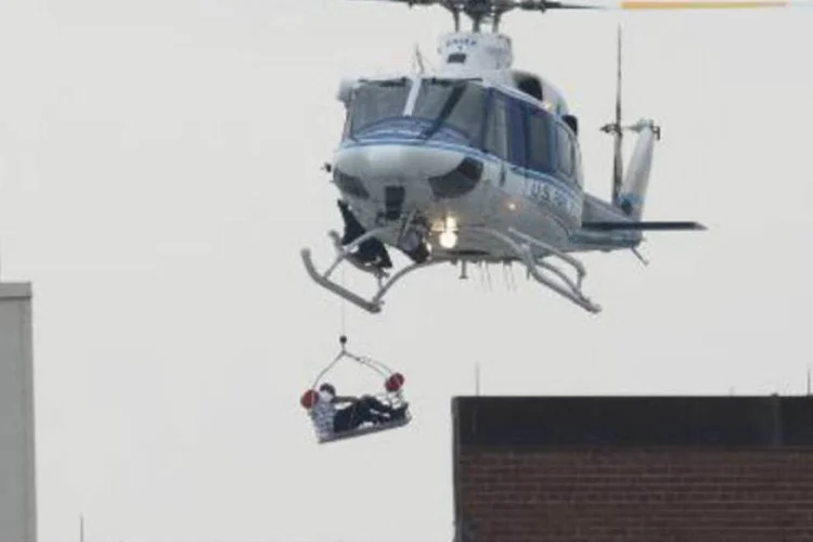 
	Um helic&oacute;ptero sobrevoa a regi&atilde;o do complexo naval americano em Washington em que um atirador foi morto e outros dois se encontram foragidos, depois dos disparos realizados nesta segunda-feira
 (AFP)