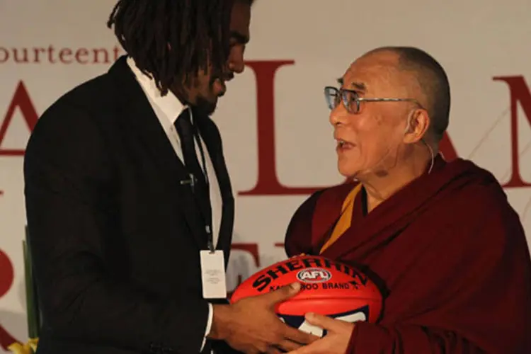 Dalai Lama estava sorridente durante um ato em que o jogador de rugby australiano Harry O'Brien entregou a ele uma bola
 (Hamish Blair/Getty Images)
