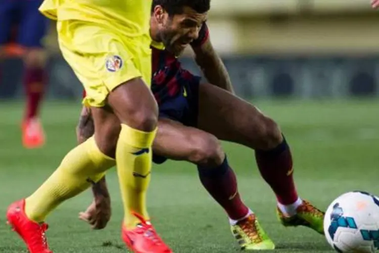 
	Daniel Alves, do Barcelona, em a&ccedil;&atilde;o contra o Villareal: ao perceber a banana atirada em sua dire&ccedil;&atilde;o, o jogador pegou-a do ch&atilde;o, descascou-a e comeu-a
 (Jaime Reina/AFP)