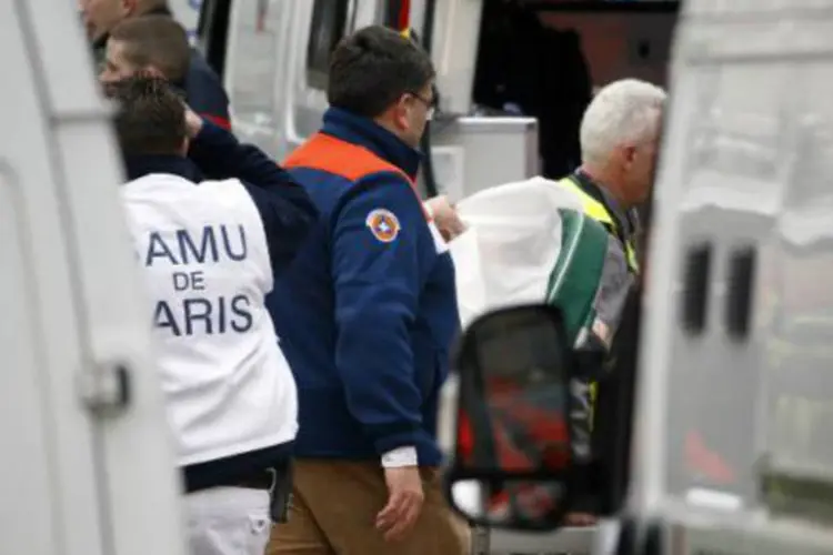 
	Defesa civil em frente &agrave; sede do Charlie Hebdo: dez jornalistas e dois policiais foram mortos
 (Kenzo Tribouillard/AFP)