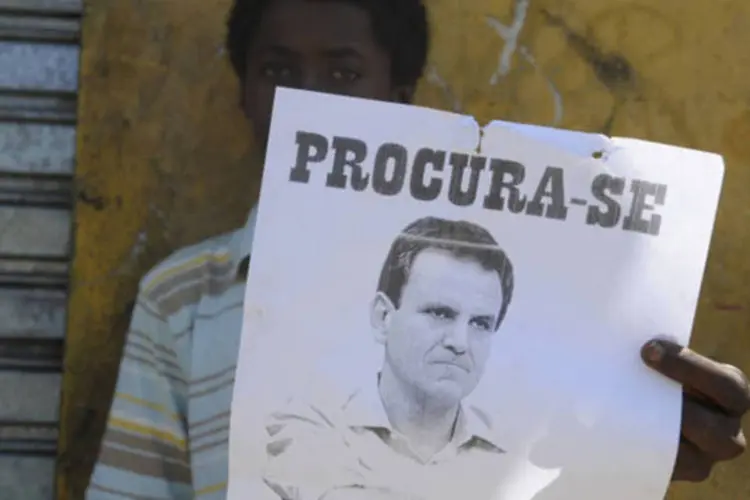 Morador da Comunidade do Metrô, que fica às margens da Avenida Radial Oeste e próxima ao Maracanã, com cartaz de protesto contra o prefeito Eduardo Paes (Tânia Rêgo/ABr)