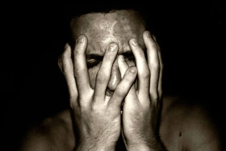 Homem deprimido com as mãos no rosto (Stock Exchange)