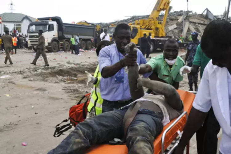 Homem ferido é retirado dos escombros de prédio que desabou, em Gana: segundo testemunhas, o edifício, que ficava na zona norte de Acra, desabou por volta das 10h locais (REUTERS)